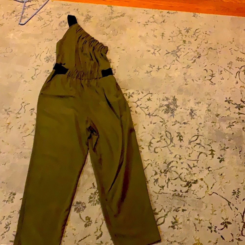 Green jump suit. One shoulder with black banding.